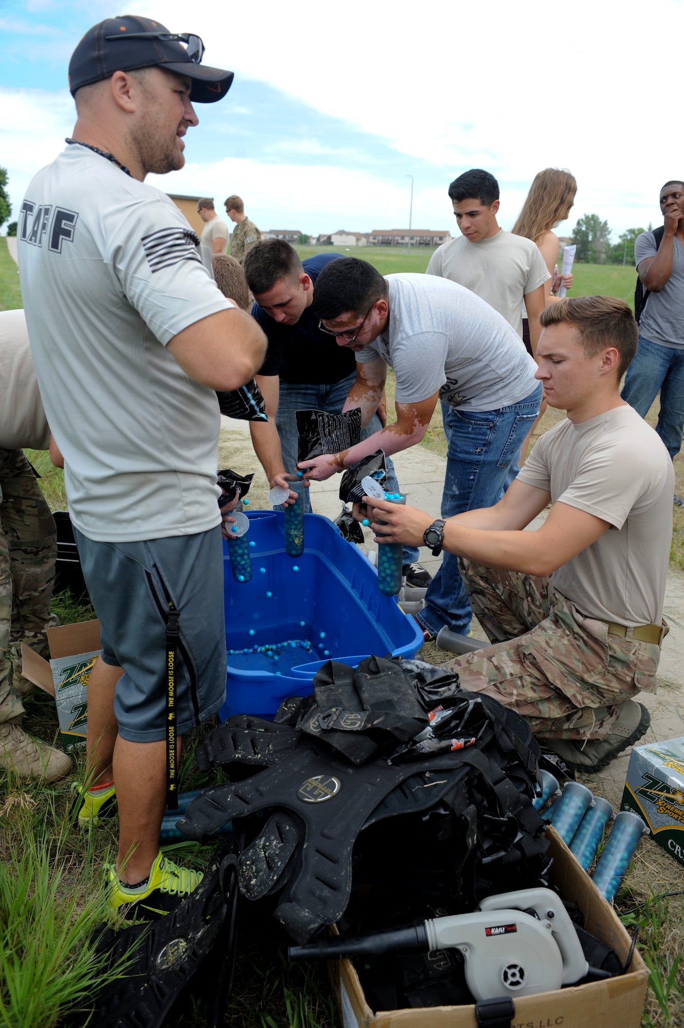 Volunteers assist with set up for a paintball tournament during the annual base picnic at Ellsworth Air Force Base, S.D., July 10, 2015. Items required to play in the tournament included protective masks, paintball guns, and different colored paints to identify opposing teams. (U.S. Air Force photo by Airman 1st Class Denise M. Nevins/Released)