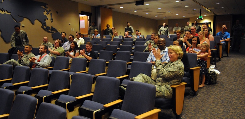 Members of the 50th Space Wing cheer as they watch the launch of the Wideband Global Satcom-7 satellite during a launch party in the Building 300 auditorium Thursday, July 23, 2015. The WGS-7 launch marks the seventh of 10 scheduled launches which will compose the WGS constellation and phase out the Defense Satellite Communications System. (U.S. Air Force photo/Staff Sgt. Debbie Lockhart)