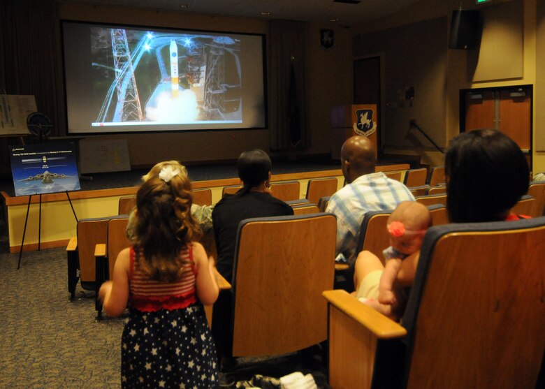 Members of the 50th Space Wing watch the launch of the Wideband Global Satcom-7 satellite during a launch party in the auditorium Thursday, July 23, 2015. In order to highlight this mission with members assigned outside of 3rd Space Operations Squadron and share this event with family members, 3 SOPS held a launch party and sent out an invitation base-wide. (U.S. Air Force photo/Staff Sgt. Debbie Lockhart)