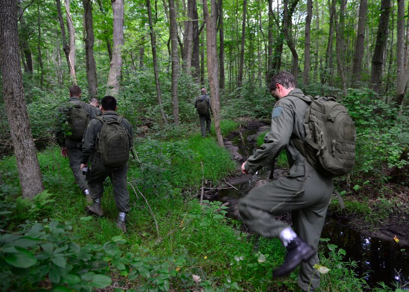 An aircrew follows a creek while navigating and evading enemy forces during a combat survival training exercise July 16, 2015, at the Blackbird State Forest near Smyrna, Del. The aircrew had to navigate through several miles of forest while trying to evade enemy forces to be rescued by friendly personnel. (U.S. Air Force photo/Airman 1st Class William Johnson)