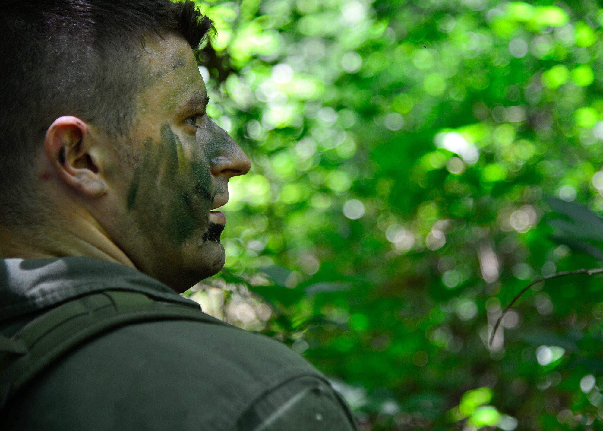 Senior Airman Dan Bates, 9th Airlift Squadron C-5M Super Galaxy loadmaster, checks a path for enemy forces before crossing during a combat survival training exercise July 16, 2015, at the Blackbird State Forest near Smyrna, Del. The refresher survival training is required to be completed every three years by aircrew members. (U.S. Air Force photo/Airman 1st Class William Johnson)