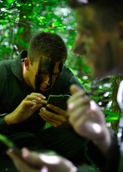 Capt. Rob Willoughby, 9th Airlift Squadron C-5M Super Galaxy pilot, applies camouflage paint to his face during a combat survival training exercise July 16, 2015, at the Blackbird State Forest near Smyrna, Del. Willoughby was part of a five-man team that was evading enemy forces after being captured in the exercise. (U.S. Air Force photo/Airman 1st Class William Johnson) 