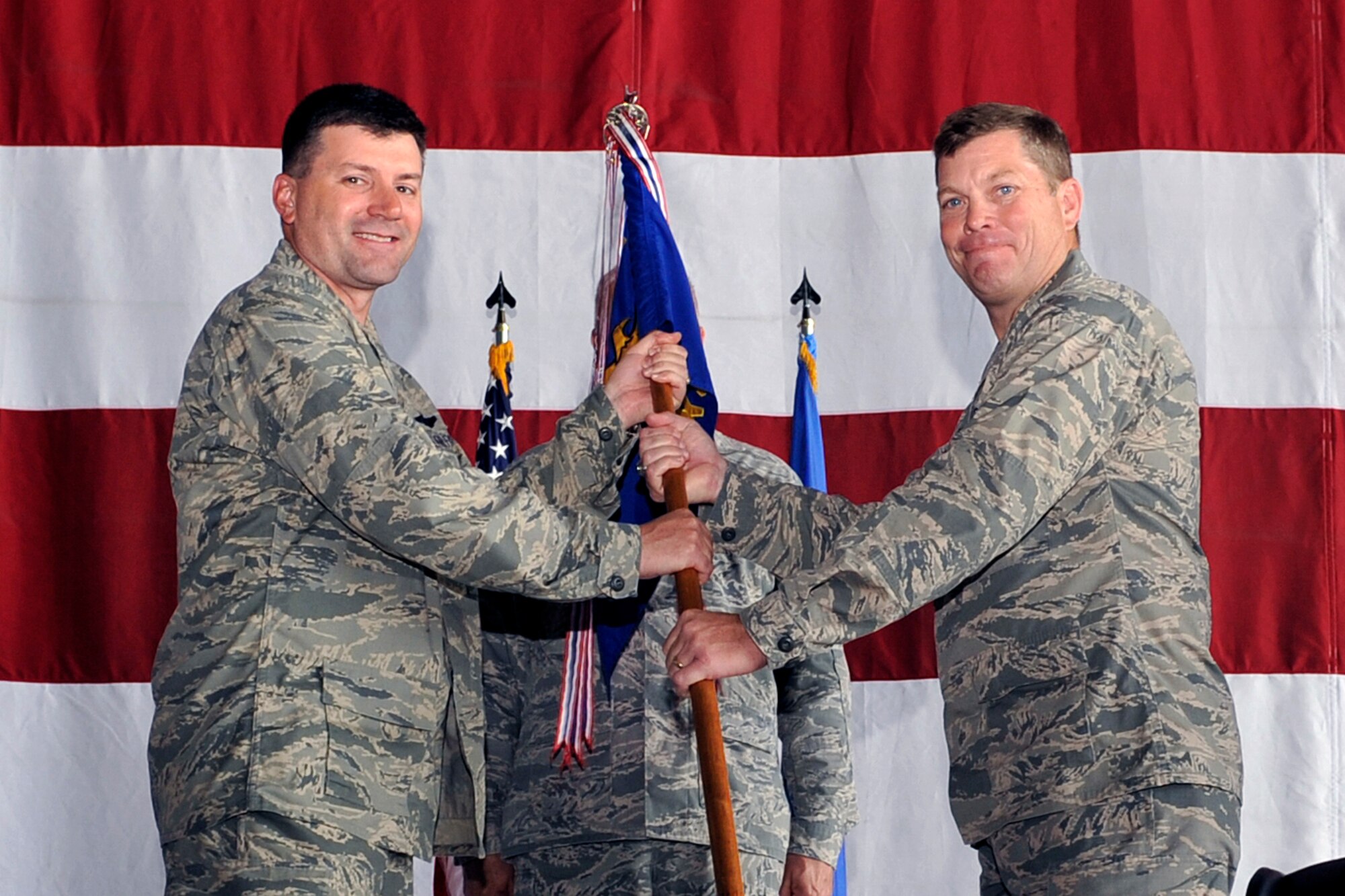 U.S. Air Force Col. Clayton Seale, right, assumes command of the 55th Maintenance Group from U.S. Air Force Col. Marty Reynolds, 55th Wing commander, during a change of command ceremony held inside the Benny L. Davis Maintenance Facility July 27, 2015 at Offutt Air Force Base, Nebraska. (U.S. Air Force photo by Jeff Gates/Released)