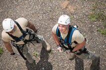 Airmen from the 5th Civil Engineer Squadron watch their fellow Airmen practice rappelling at Minot Air Force Base, N.D., July 9, 2015. The rescue side of the fire station is an additional advanced course that requires a firefighter to go back to the fire academy for 30 days to get trained as a rescue technician. (U.S. Air Force photo/ Airman 1st Class Justin T. Armstrong)