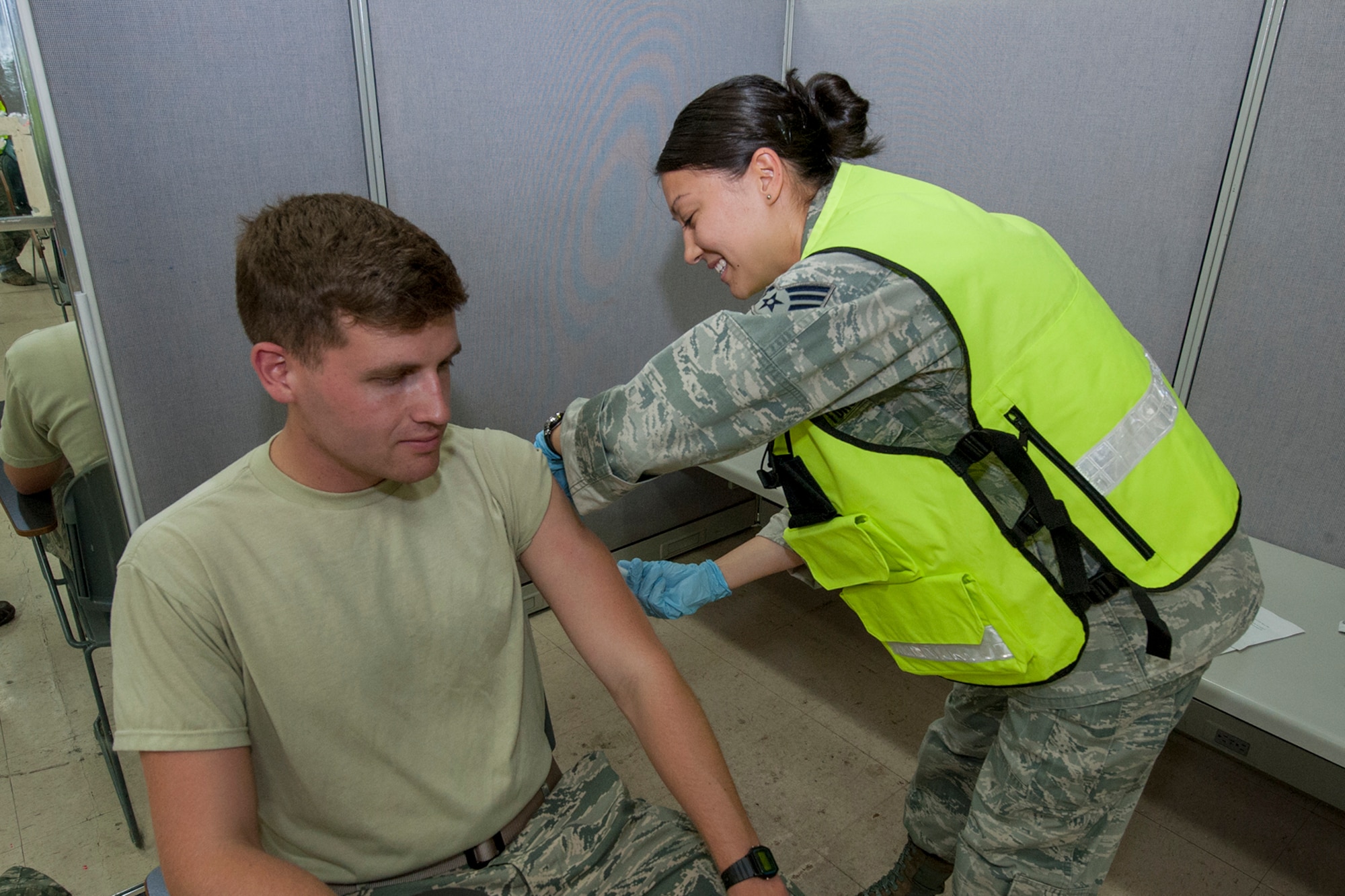 PETERSON AIR FORCE BASE, Colo.—Senior Airman Jamie Ortiz, 21st Medical Operations Squadron simulates administering a measles vaccine to Airman 1st Class Jacob Davis, 3rd Space Operations Squadron, during a base-wide exercise July 16, 2015. The exercise scenario was a measles outbreak that originated at a nearby tourist attraction during a military appreciation weekend. As part of the response, the 21st Medical Group set up a vaccine distribution point on base where Airmen and their families from Peterson and Schriever Air Force Base could receive treatment if they were experiencing symptoms. (U.S. Air Force photo by Philip Carter)
