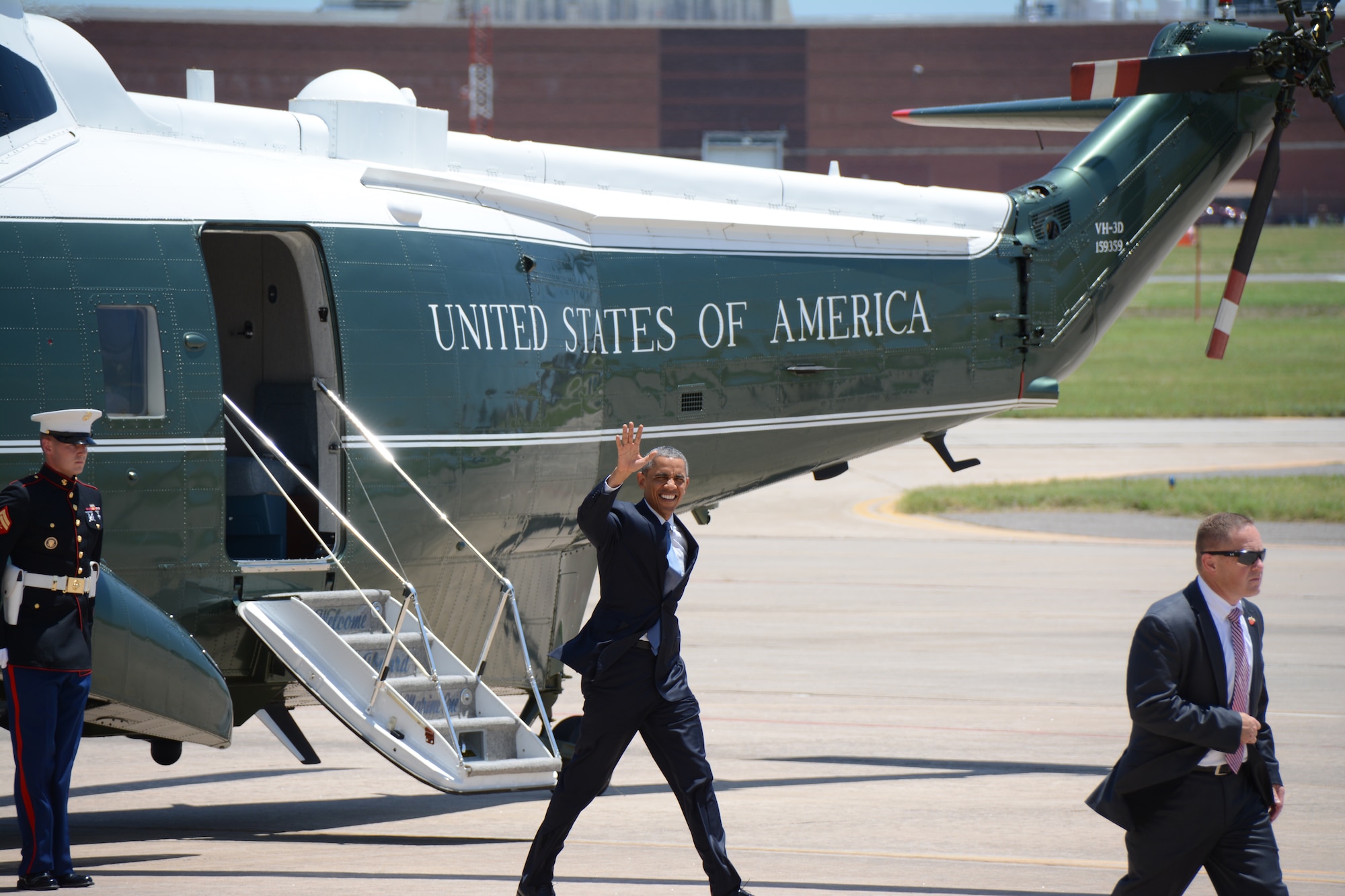 President Barack Obama waves farewell to a small group of media and base personnel at Tinker Air Force Base, Okla. July 16, 2015. Obama and Federal Bureau of Prisons Director Charles E. Samuels, Jr., met with six inmates and staff to discuss sentencing reform at the Federal Correctional Institute El Reno. Reservists, civilians, and active-duty Airmen provided support for the arrival and departure of the president. (U.S. Air Force Photo/ Staff Sgt. Lauren Gleason)