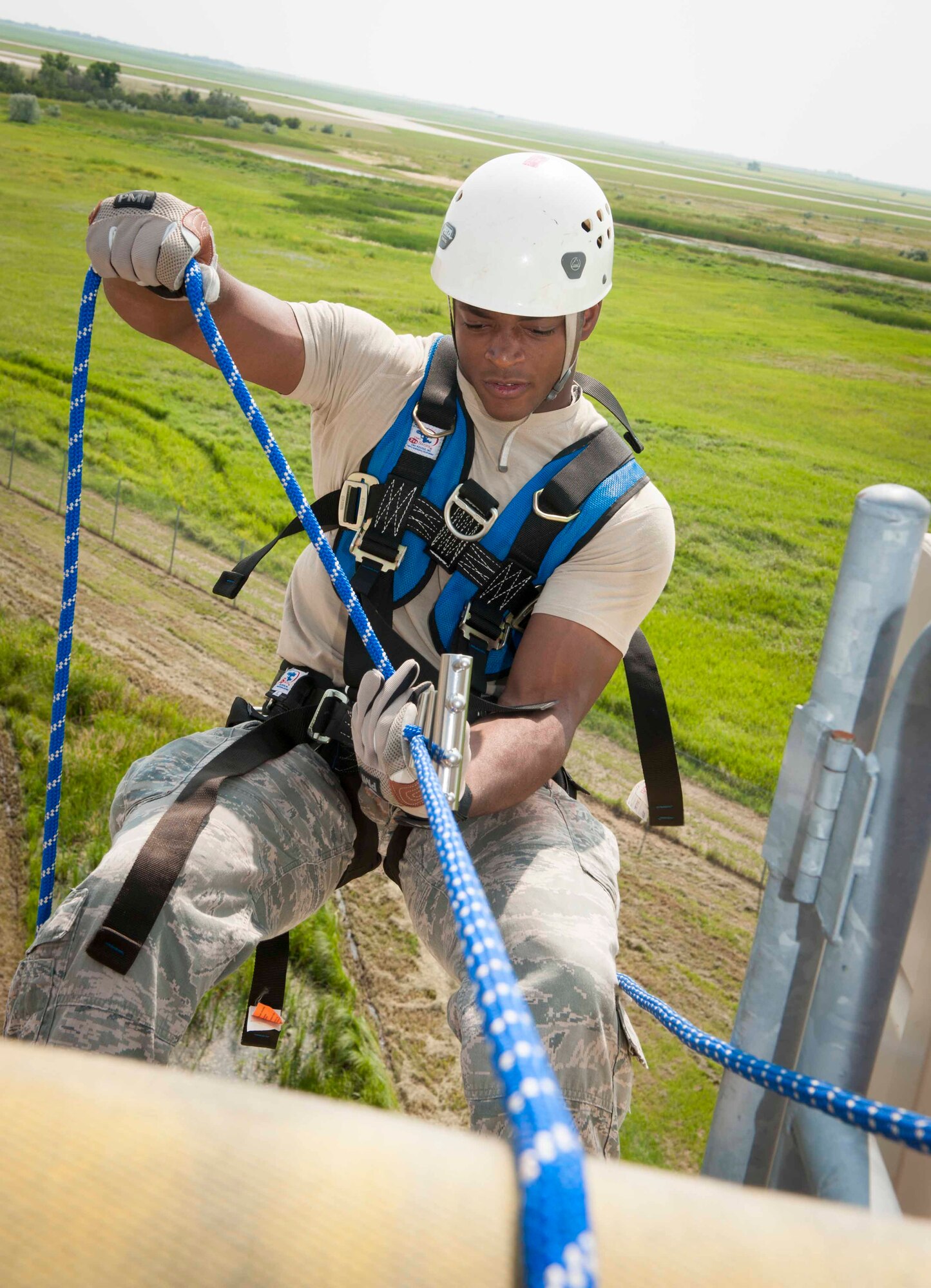 An Airman from the 5th Civil Engineer Squadron practices rappelling down the side of a building at Minot Air Force Base, N.D., July 9, 2015. The rescue side of the fire station is an additional advanced course that requires a firefighter to go back to the fire academy for 30 days to receive training as a rescue technician. (U.S. Air Force photo/Airman 1st Class Sahara L. Fales)