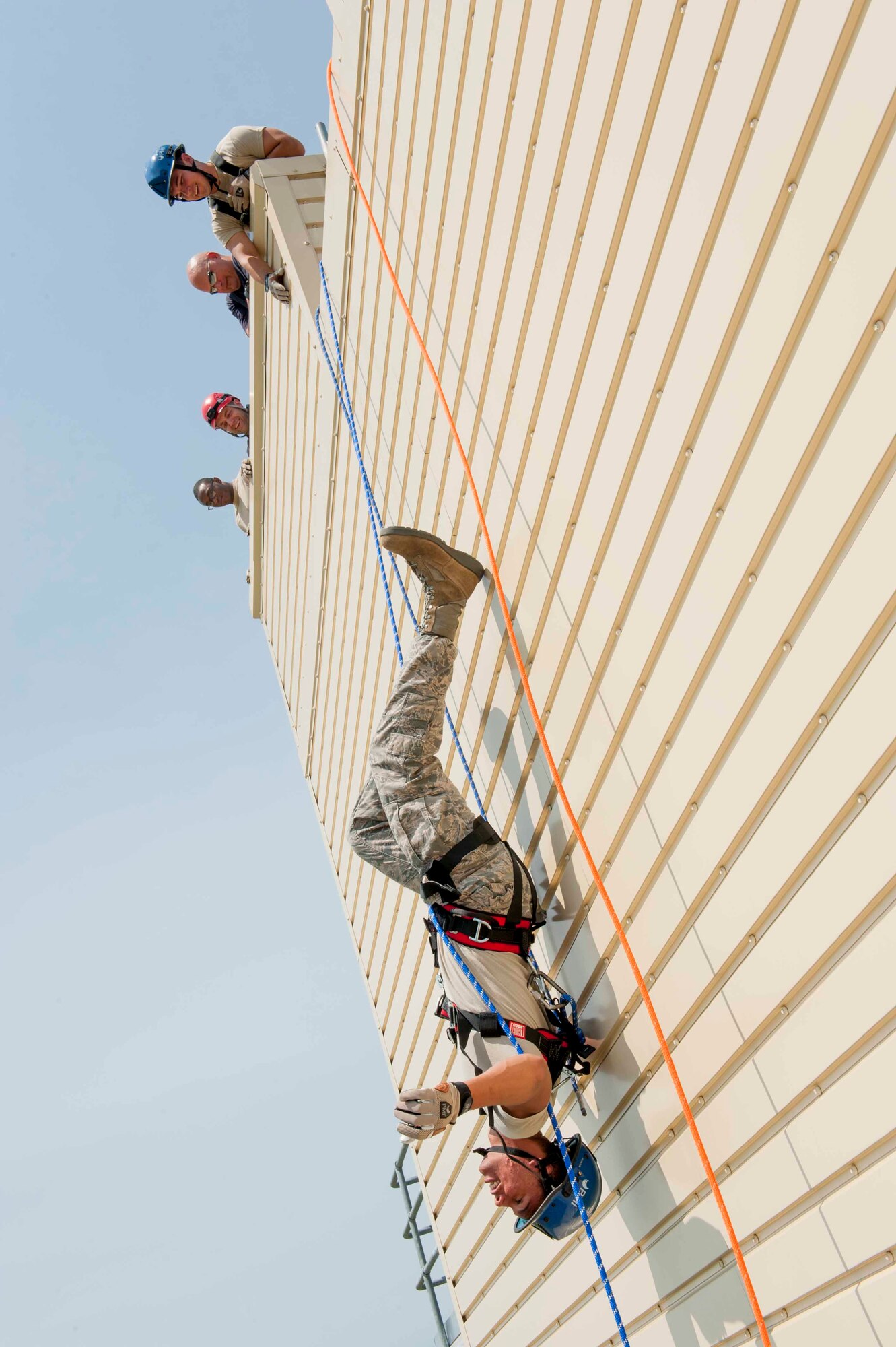 An Airman from the 5th Civil Engineer Squadron hangs upside down during rappelling training at Minot Air Force Base, N.D., July 9, 2015. Repelling was a portion of a rope rescue class provided to Airmen to prepare them to descend down the side of buildings or enter confined spaces. (U.S. Air Force photo/Airman 1st Class Sahara L. Fales)