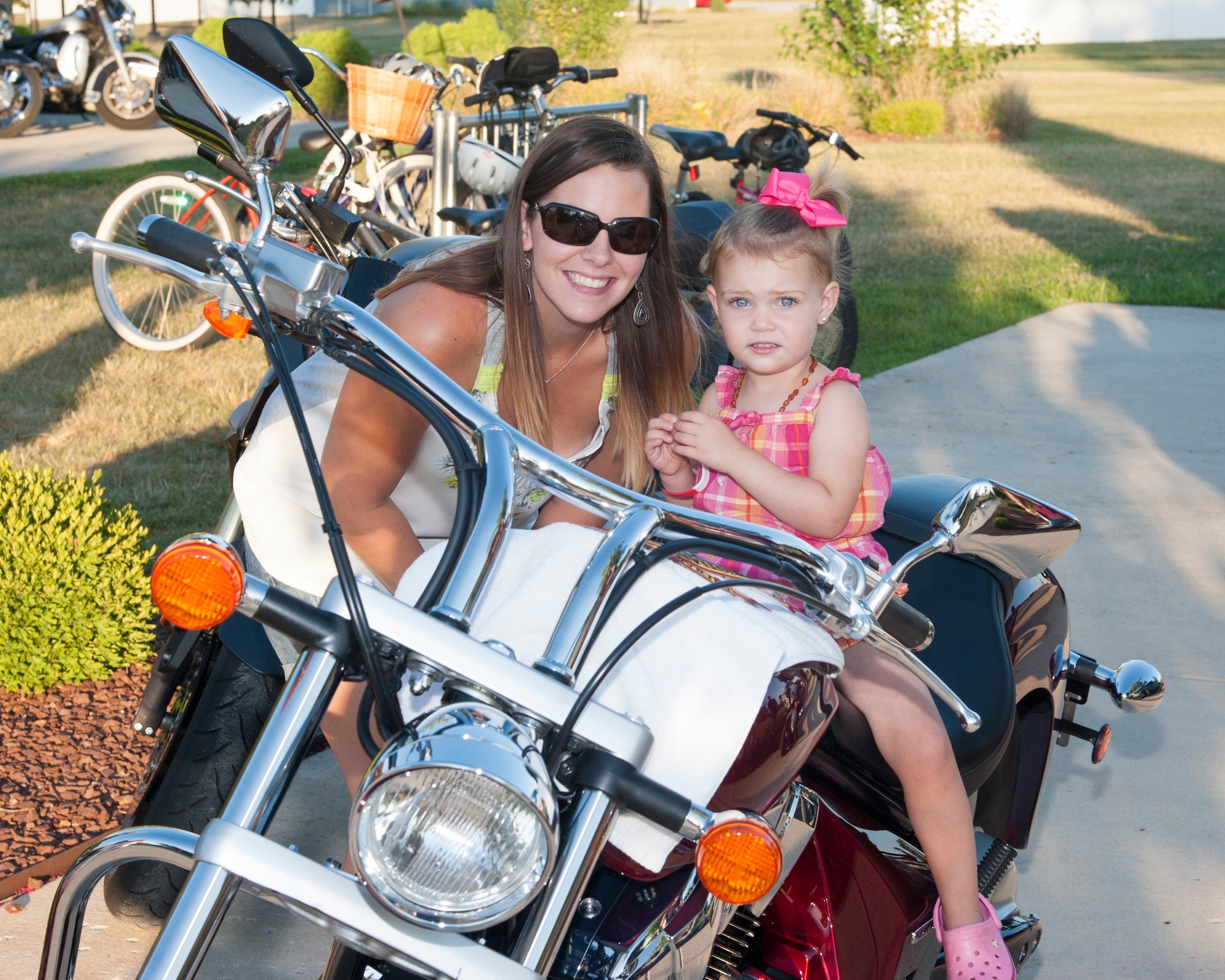 Amber Odom, wife of Staff Sgt. Zachary Odom, 3d Airlift Squadron loadmaster, and their daughter, Scarlette, pose for a photo on a motorcycle during the Deployed Families Dinner July 23, 2015, at the Youth Center on Dover Air Force Base, Del. The theme for the event was Beaches and Bikes and it was hosted by the 436th Maintenance Group. (U.S. Air Force photo/Senior Airman Jared Duhon) 