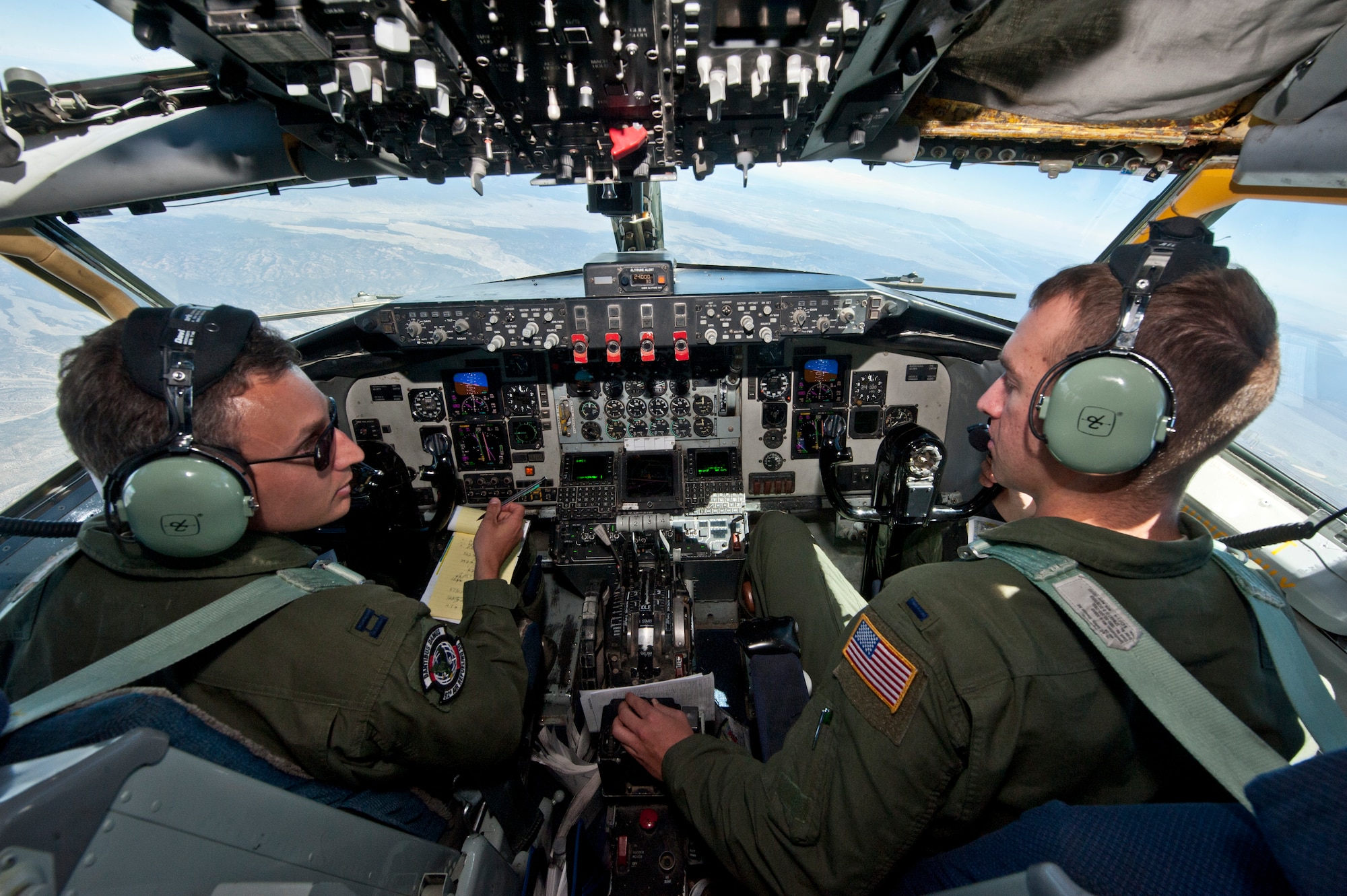 Capt. Taylor Ellington and 1st Lt. Matthew Street, both pilots assigned to the 92nd Air Refueling Wing, Fairchild Air Force Base, Wash., discuss notes while flying a Red Flag 15-3 training mission over the Nevada Test and Training Range, July 24, 2015. During Red Flag, KC-135s circle the skies refueling fighter aircraft to expand their training missions. (U.S. Air Force photo by Airman 1st Class Jake Carter)