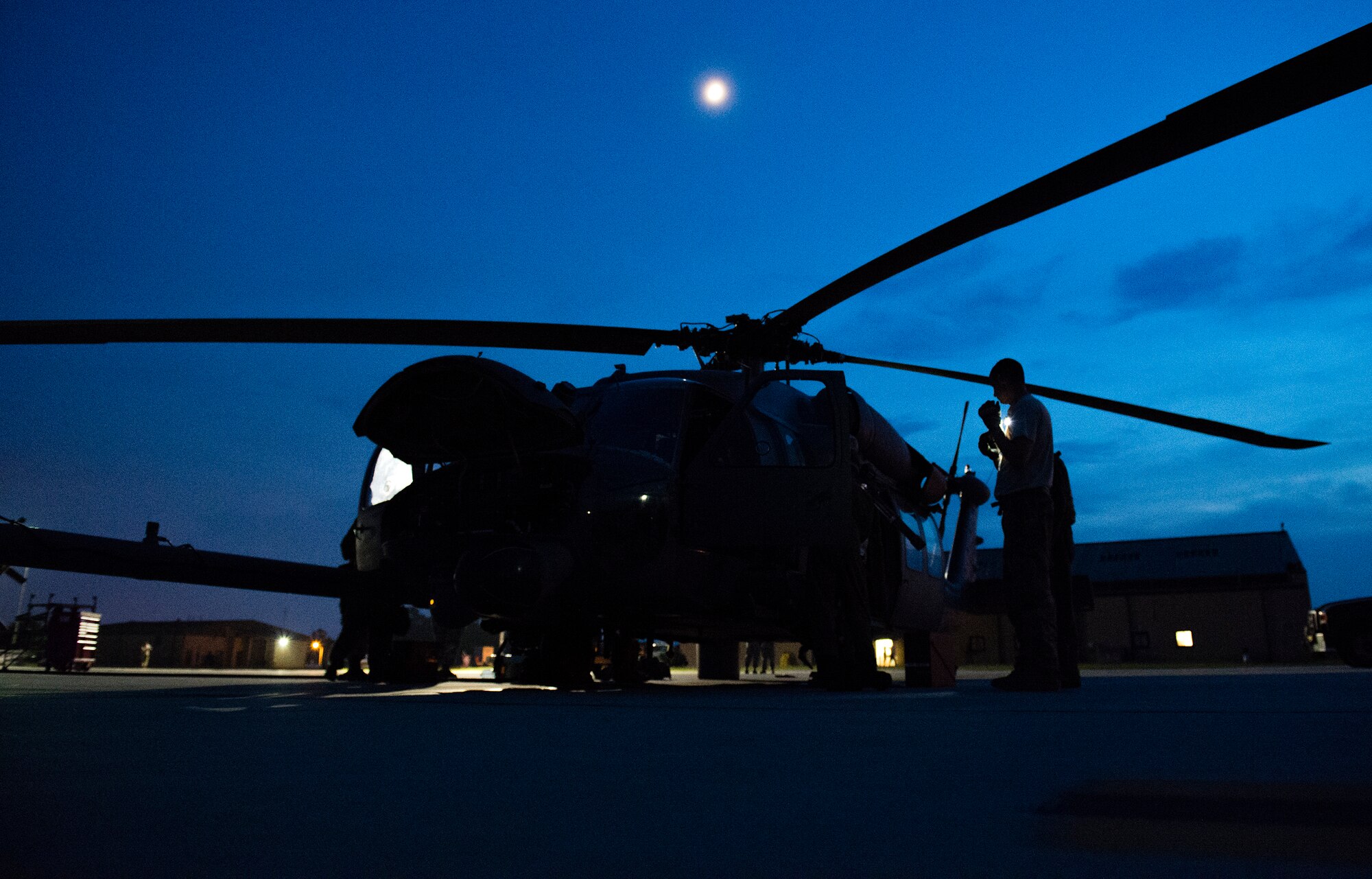 An HH-60G Pave Hawk rests on the flight line as 41stt Rescue Squadron special missions aviators and 41st Helicopter Maintenance Unit maintenance personnel perform pre-flight inspections July 21, 2015, on Moody Air Force Base, Ga. The Pave Hawk can hold two .50 caliber machineguns or two GAU-2/A 7.62 mm miniguns that are operated by special missions aviators. The 41st RQS that is an HH-60G personnel recovery squadron, specializes in combat rescue of down aircrews and. (U.S. Air Force photo/Tech. Sgt. Zachary Wolf/Released)