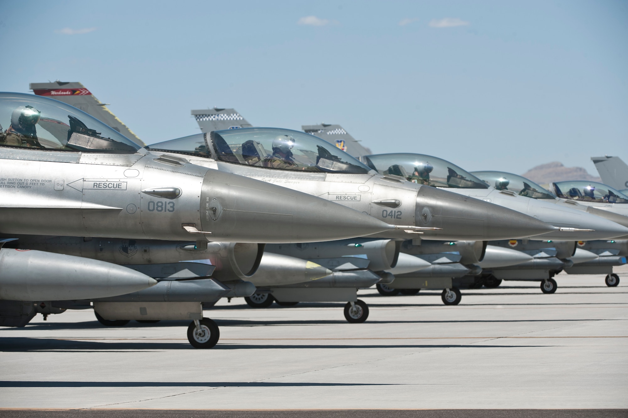 Pilots from Shaw Air Force Base, S.C., and Spangdalam Air Base, Germany wait for take off while pre-flight checks are performed on their aircraft on the flightline at Nellis Air Force Base, Nev., July 23, 2015. Units from around the world came to experience and participate in the best training they can receive in the air, space and cyberspace realm of operations. (U.S. Air Force photo by Airman 1st Class Jake Carter)