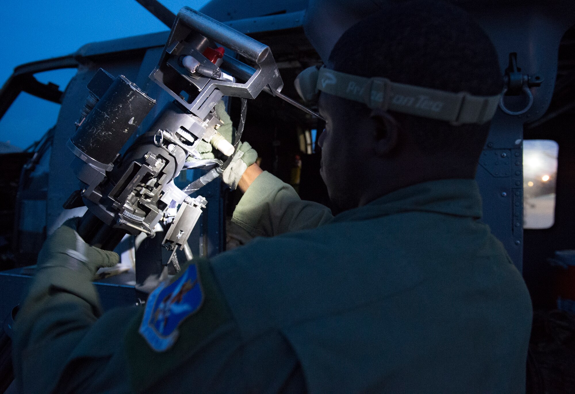 Tech. Sgt. Uwemediimo Essien, 41st Rescue Squadron special missions aviator, inspects a GAU-2/A 7.62 mm minigun during preflight checks July 21, 2015, at Moody Air Force Base, Ga. Essien always had an interest in aviation since riding in a helicopter when he was four and decided he wanted to become an aerial gunner after watching an interview online about what they do. (U.S. Air Force photo/Tech. Sgt. Zachary Wolf/Released)