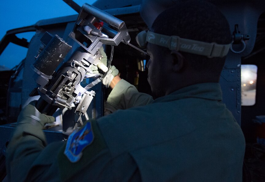 Tech. Sgt. Uwemediimo Essien, 41st Rescue Squadron special missions aviator, inspects a GAU-2/A 7.62 mm minigun during preflight checks July 21, 2015, at Moody Air Force Base, Ga. Essien always had an interest in aviation since riding in a helicopter when he was four and decided he wanted to become an aerial gunner after watching an interview online about what they do. (U.S. Air Force photo/Tech. Sgt. Zachary Wolf/Released)