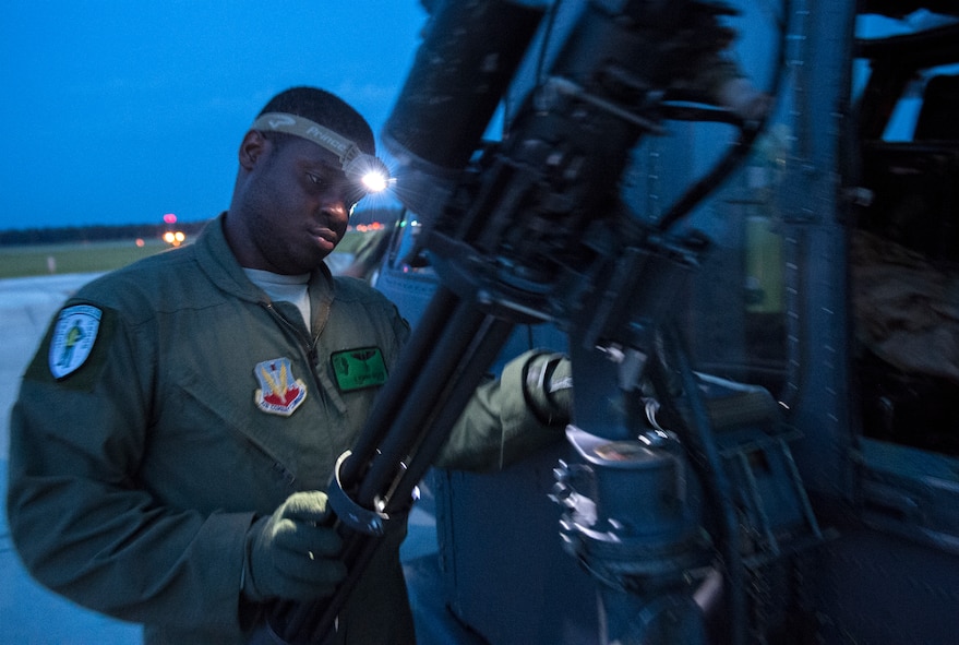 Tech. Sgt. Uwemediimo Essien, 41st Rescue Squadron special missions aviator, inspects a GAU-2/A 7.62 mm minigun during pre-flight checks July 21, 2015, at Moody Air Force Base, Ga. Essien moved to America from Nigeria when he was 12 years old. He joined the Air Force right out of high school and started his career as a medical administrator before crosstraining into the aerial gunner career field. (U.S. Air Force photo/Tech. Sgt. Zachary Wolf/Released)