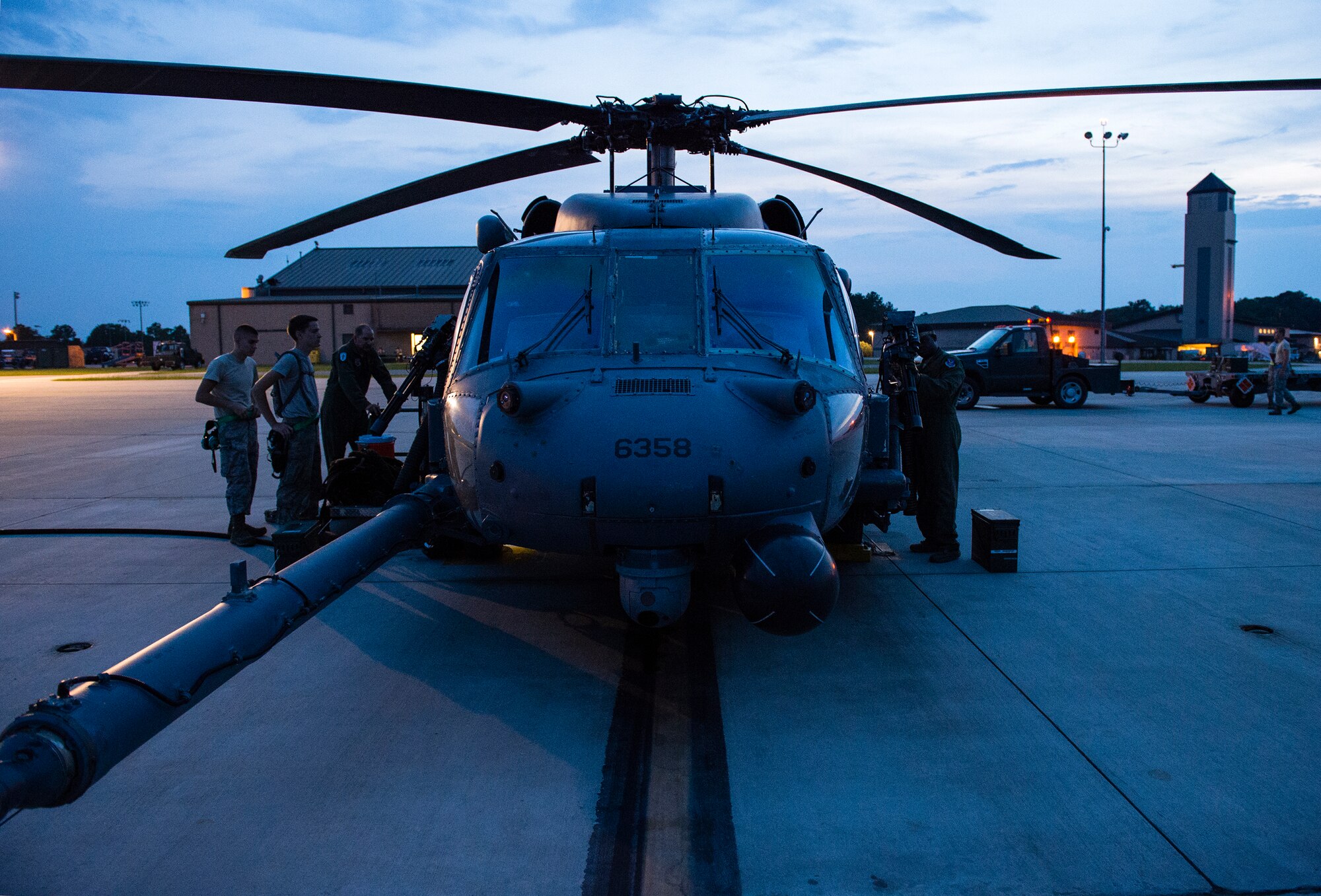 An HH-60G Pave Hawk rests on the flight line as 41stt Rescue Squadron special missions aviators perform preflight inspections July 21, 2015, on Moody Air Force Base, Ga. Tech. Sgt. Uwemediimo Essien, 41st RQS special missions aviator, said he had trouble with the water survival portion of his training, but spent his time and money practicing treading water at the base pool and went back and passed that portion. (U.S. Air Force photo/Tech. Sgt. Zachary Wolf/Released)