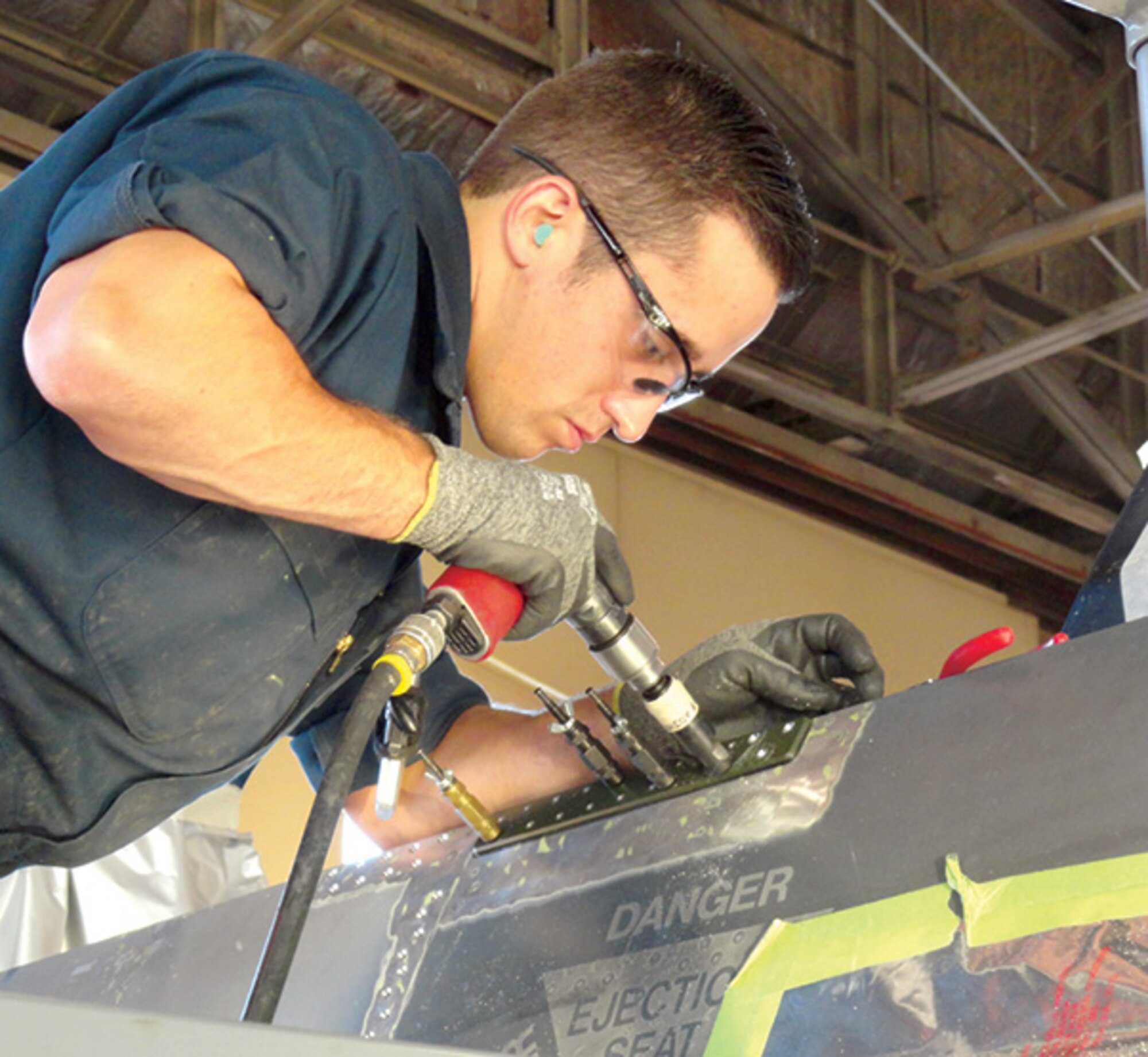 Staff Sgt. Joseph Kern, 309 AMXG DSM specialist, countersinks an aluminum canopy sill longeron strap to an F-16D.   (Courtesy photo)