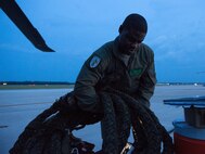 Tech. Sgt. Uwemediimo Essien, 41st Rescue Squadron special missions aviator, prepares to load an HH-60G Pave Hawk during pre-flight checks July 21, 2015, on Moody Air Force Base, Ga. After attaining his U.S. citizenship, Essien applied three times to become an aerial gunner before it merged with flight engineers and became the special missions aviation career field. (U.S. Air Force photo/Tech. Sgt. Zachary Wolf/Released)