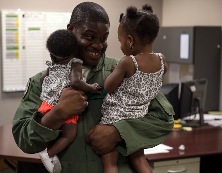 Tech. Sgt. Uwemediimo Essien, 41stt Rescue Squadron special missions aviator, plays with his daughters before going out to perform pre-flight inspections on an HH-60G Pave Hawk July 21, 2015, on Moody Air Force Base, Ga. Essien said it was important to him to find the balance between his career and family and he‘s lucky to have found someone who understands his job. (U.S. Air Force photo/Tech. Sgt. Zachary Wolf/Released)