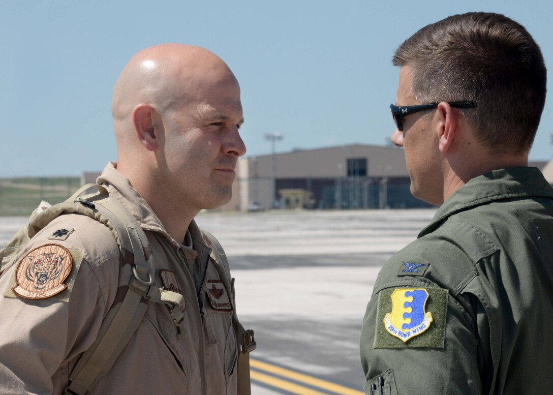 Col. John Martin, 28th Operations Group commander (right), speaks with Lt. Col Joseph, 37th Bomb Squadron commander, prior to his departure for deployment at Ellsworth Air Force Base, S.D., July 24, 2015. Approximately 350 Ellsworth Airmen deployed in support of missions in the U.S. Central Command area of responsibility. (U.S. Air Force photo by Senior Airman Rebecca Imwalle/Released)