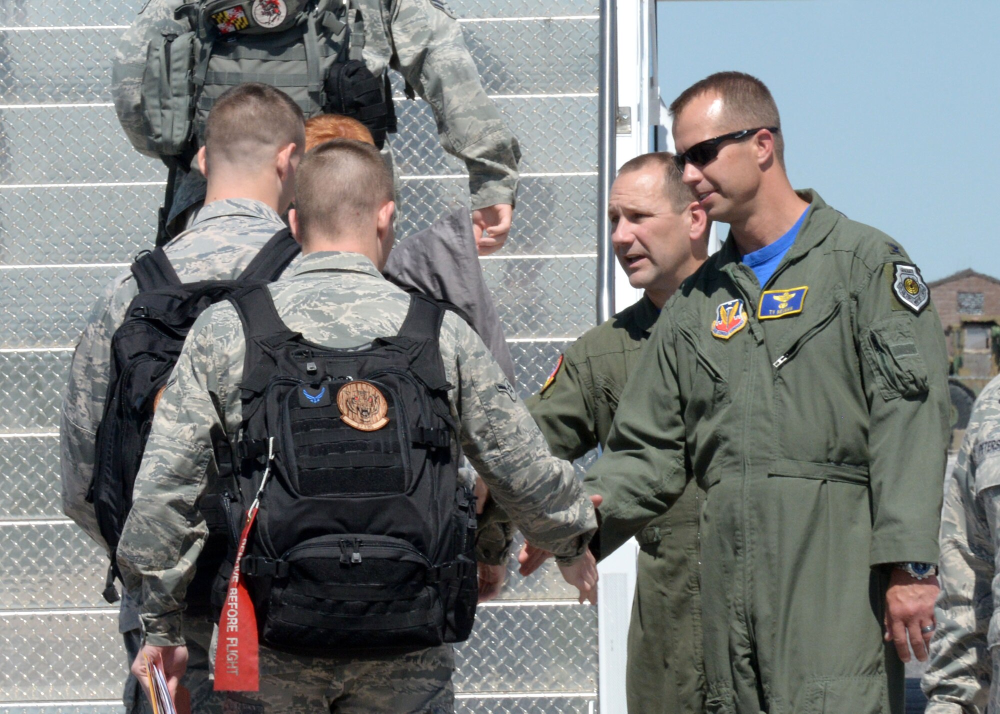 Col. Ty Neuman, 28th Bomb Wing vice commander (right), and Col. Gentry Boswell, 28th BW commander, shake the hands of deploying Airmen as they prepare to depart Ellsworth Air Force Base, S.D., July 24, 2015. Ellsworth aircrews, maintenance and support personnel will execute B-1 missions designed to provide multi-role air power in support of U.S. and coalition forces. (U.S. Air Force photo by Senior Airman Rebecca Imwalle/Released)