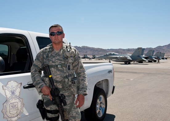 Airman 1st Class Michael Cordova, 99th Security Forces Squadron member, stands guard on the flightline during Red Flag 15-3 on Nellis Air Force Base, Nev., July 17, 2015. While on duty, Cordova provides security, armed response to any priority-level resource in his assigned area of operation, and ensures only authorized personnel are on the flightline. During Red Flag exercises, Cordova’s assigned area of operation includes over 100 aircraft. (U.S. Air Force photo by Airman 1st Class Jake Carter)