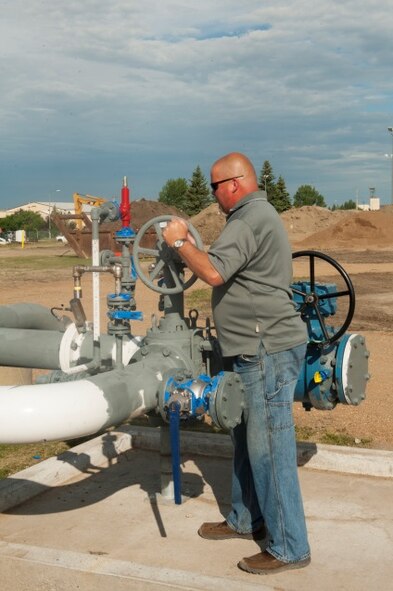 A contractor turns the wheel letting fuel flow through the new pipelines at Minot Air Force Base, N.D., July 21, 2015. The new pipeline holds only 25,000 gallons of jet fuel compared to the 54,000 gallons before the renovation. (U.S. Air Force photo/Airman 1st Class Christian Sullivan)