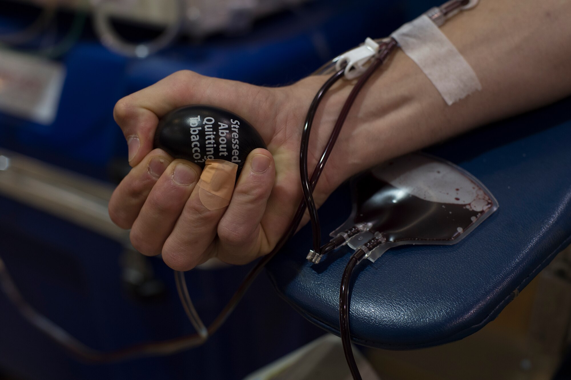 U.S. Air Force Capt. Nicholas Gumley, 93d Air Ground Operations Wing comptroller, squeezes a stress ball to increase blood circulation during a blood drive July 22, 2015, at Moody Air Force Base, Ga. Gumely was one of several service members to donate blood through a haemonetics machine that sorts blood cells and plasma. (U.S. Air Force photo by Staff Sgt. Eric Summers Jr./Released)