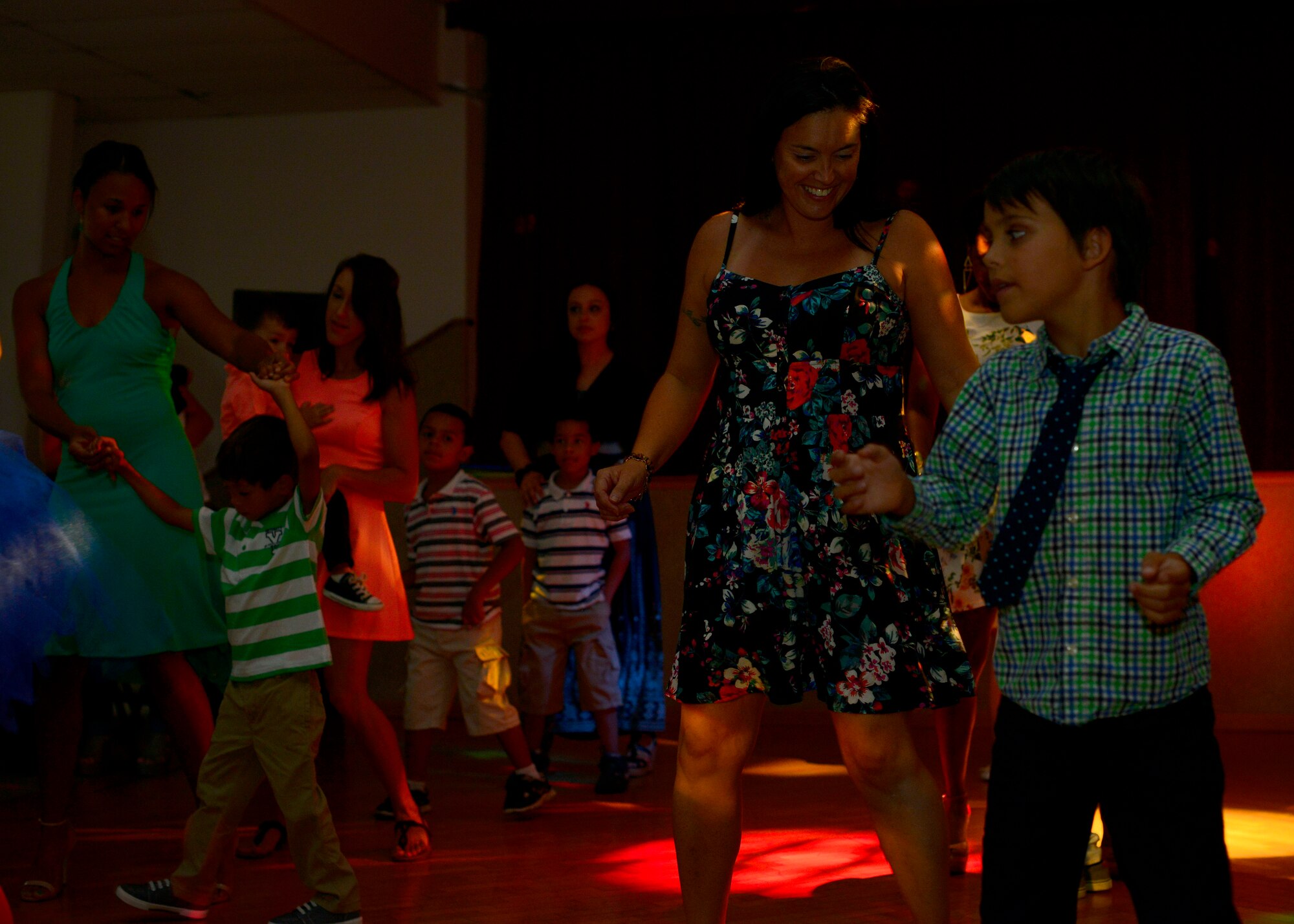 A group of mothers and sons dance during the first “Mother and Son dance,” July 25, 2015, at Aviano Air Base, Italy. The dance offered a night of bonding for mothers and their sons with hours of music and games. (U.S. Air Force photo by Airman 1st Class Cary Smith/Released)