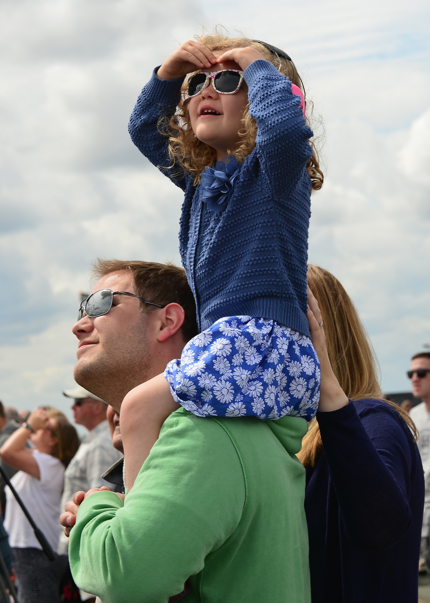 Nick Barclay carries daughter Freya Barclay on his shoulders to watch the airshow during the Families and Friends Day at Royal Air Force Marham, July 23, 2015. Fourteen flying displays took place during the airshow, including two F-15C Eagles, Typhoon FGR4, four Tornados GR4, The Falcons and the RAF Red Arrows Acrobatic Team. (U.S. Air Force photo by Staff Sgt. Stephanie Longoria/Released)