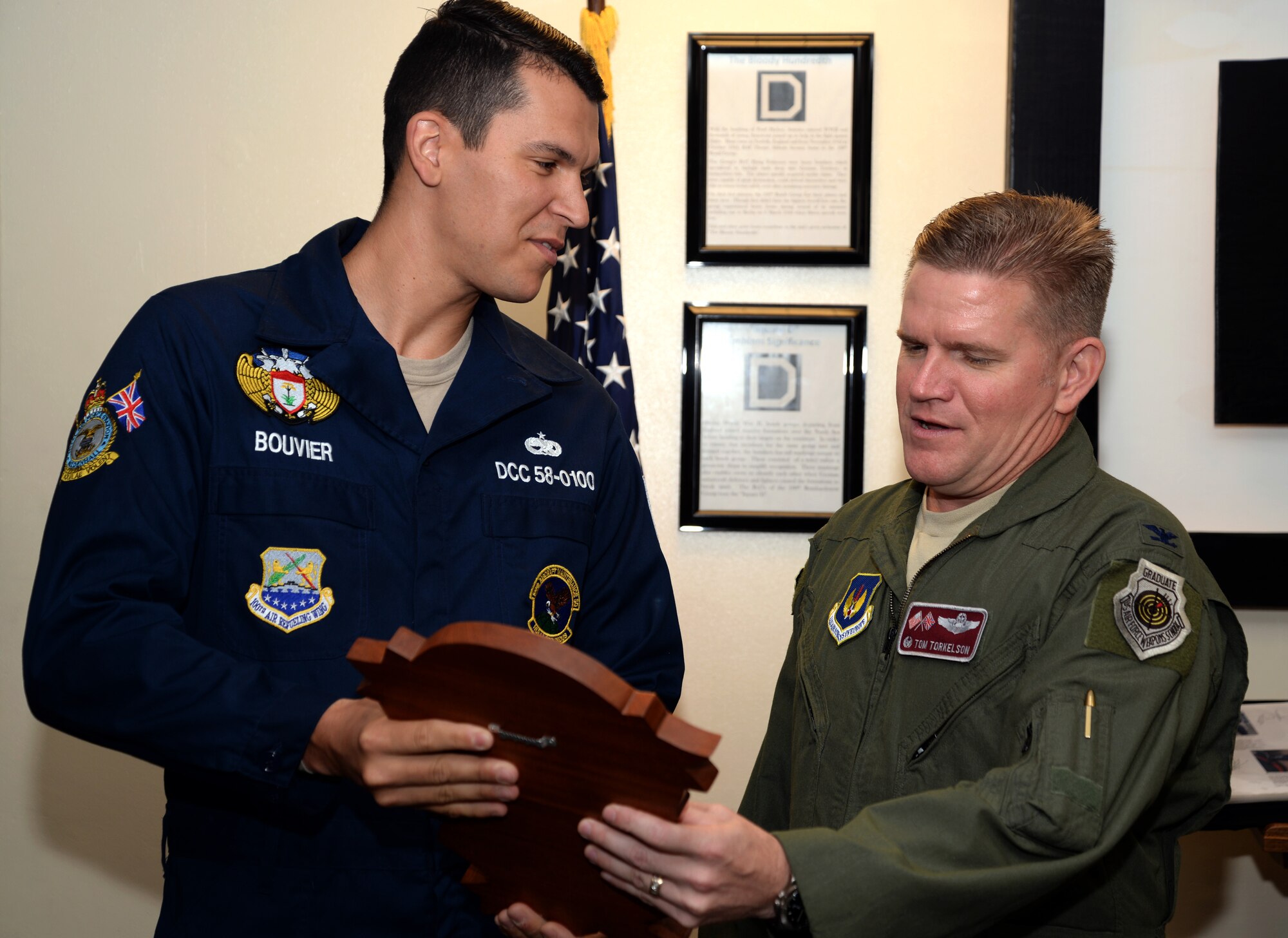 U.S. Air Force Staff Sgt. Michael Bouvier, left, 100th Aircraft Maintenance Squadron dedicated crew chief from Paris presents Col. Thomas Torkelson, 100th Air Refueling Wing commander with a DCC plaque July 27, 2015, on RAF Mildenhall, England. The plaque displays the names of maintenance Airmen responsible for the wing commander’s aircraft while he is in command. The DCC program directly assigns excellent maintenance Airmen to each aircraft and provides continuity and accuracy of forms, status, maintenance and aircraft appearance. (U.S. Air Force photo by Senior Airman Christine Halan/Released)