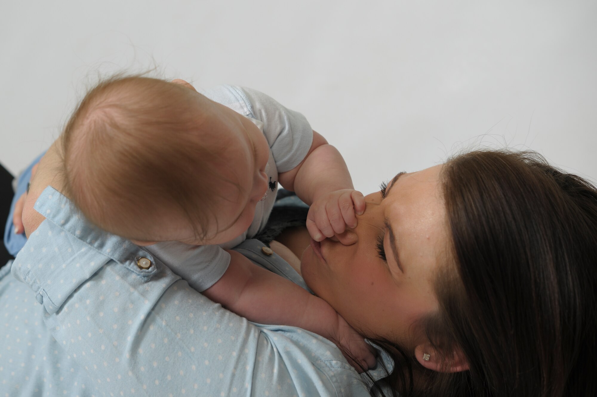 Senior Airman Dawn Weber, 48th Fighter Wing Public Affairs photojournalist and son, James, play during a photo shoot at Royal Air Force Lakenheath, England, April 15, 2015. Since becoming a mother, Weber has struggled with the option to leave active duty. With the recent changes to the post-partum policy, she said the decision to continue her service was an easy one. (U.S. Air Force photo by Senior Airman Amanda Sampson/Released)