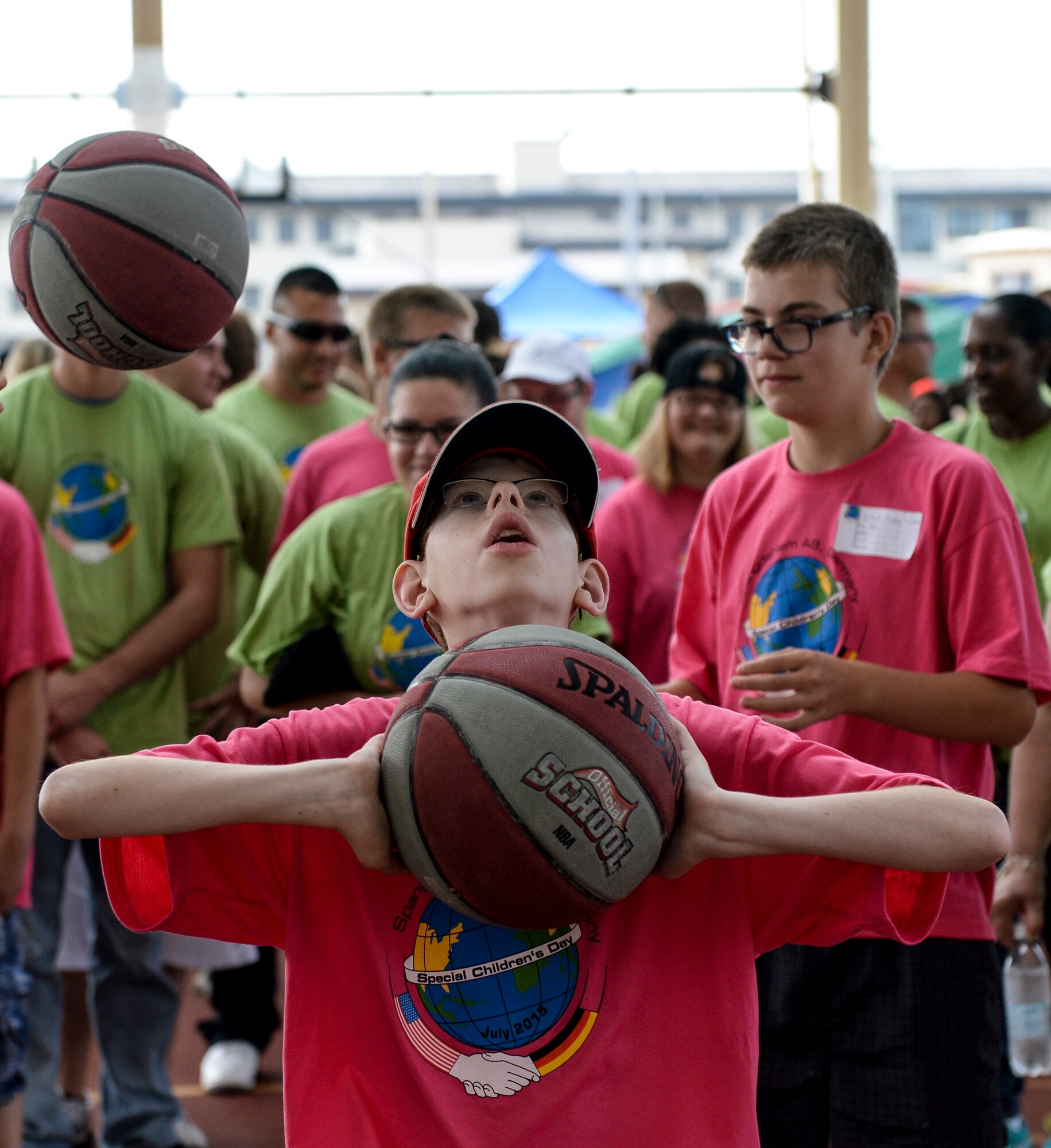 A child from St Martin’s School in Bitburg, Germany, takes part in a round of basketball during the St. Martin’s Special Children’s Day event July 22, 2015 at Spangdahlem Air Base, Germany. The base community hosted the annual event to offer a day of fun and games for special needs youth. (US Air Force photo by Senior Airman Sarah Denewellis/Released)