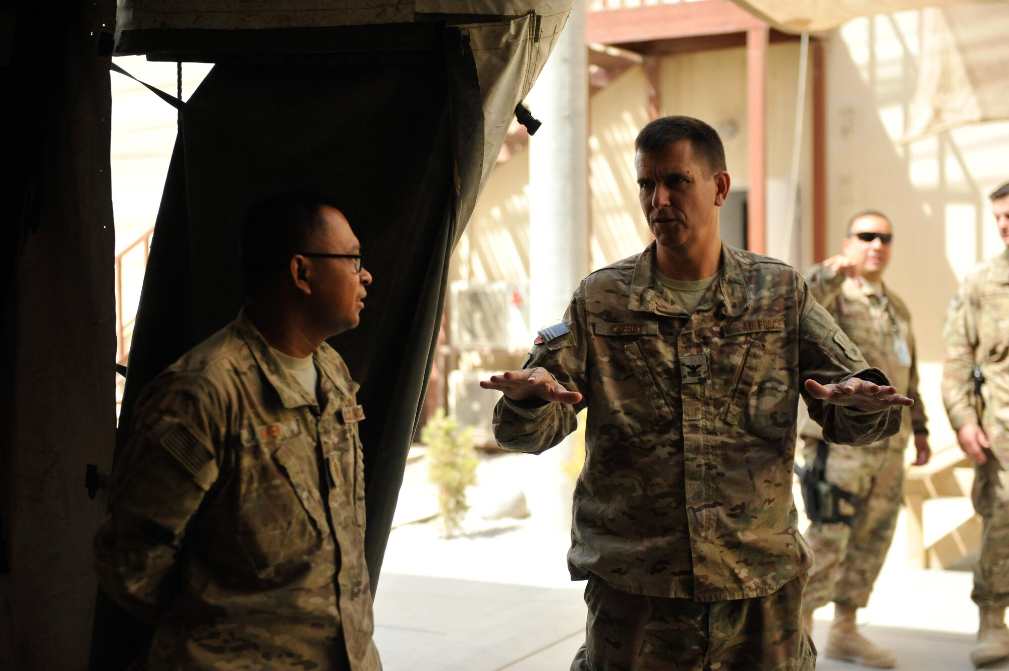 U.S. Air Force Col. Rhude Cherry, 451st Air Expeditionary Group commander talks with an Airman assigned to the 451st Air Expeditionary Group at Kandahar Airfield, July 25, 2015. Cherry hosted Brig. Gen. Dave Julazadeh, 455th Air Expeditionary Wing commander, and Chief Master Sgt. Matt Grengs, 455th AEW command chief during a battlefield circulation tour where they met with Airmen from across the group who provide intelligence, surveillance and reconnaissance for U.S. and Coalition forces operating outside the wire while also operating one of the busiest airfields in the theater.  (U.S. Air Force photo by Maj. Tony Wickman/Released)
