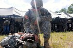 Army Capt. Peter J. Klotzbach, a chaplain with Headquarters and Headquarters Company, 53rd Brigade Support Battalion, prays over a Soldier in a mass casualty scenario during the eXportable Combat Training Capability exercise at Camp Blanding, Florida, July 24, 2014. 
