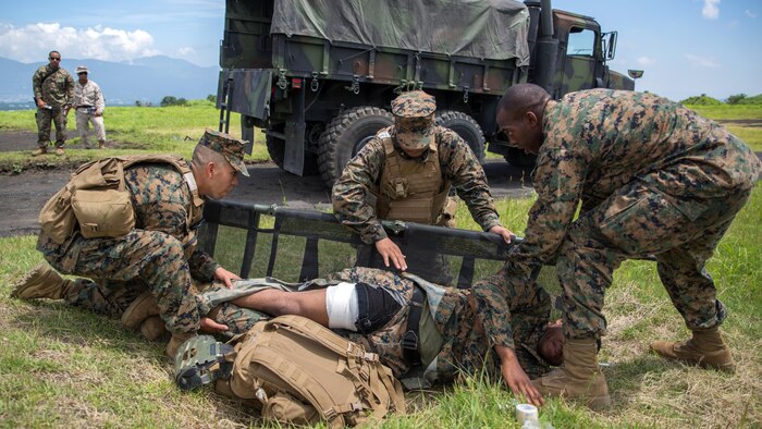 Hospital Corpsman 3rd Class Daniel Valerio, left, Hospital Corpsman Mc Joe Evans Bautista, center, and Hospital Corpsman 3rd Class Trevor A. Tisby, right, stationed with Combat Logistics Company 36 aboard Marine Corps Air Station Iwakuni, Japan, place Sgt. Kendrick Moore, a motor transport operator with CLC-36, onto the stretcher during Exercise Dragon Fire 2015 at Combined Arms Training Center Camp Fuji, Japan, July 20, 2015. Moore simulated an unexpected injury during this training scenario that allowed the corpsmen to respond as if there was a real emergency. Dragon Fire reinforces Marines’ and Sailors’ combat mindset to prepare them for the mental and physical stresses of a combat zone.