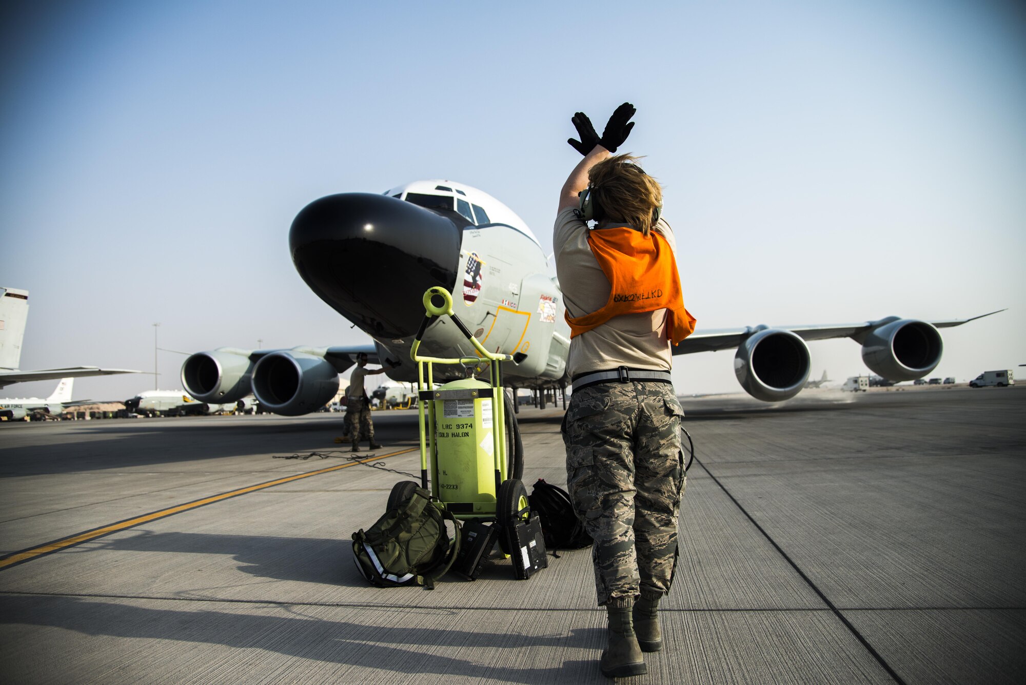 A U.S. Air Force Airman marshals an RC-135 Rivet Joint surveillance aircraft into position July 24, 2015 at Al Udeid Air Base, Qatar. The RC-135 Rivet Joint aircraft has maintained a constant presence in Southwest Asia since the early 1990s. The aircraft and crew are deployed from Offutt Air Force Base, Neb. in support of Operation Inherent Resolve and Operation Freedom’s Sentinel. (U.S. Air Force photo by Tech. Sgt. Rasheen Douglas)
