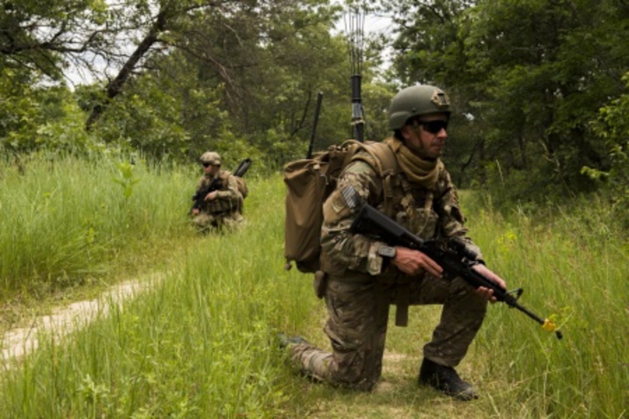 U.S. Air Force Senior Airman Troy Leatherman, 439th Civil Engineer Squadron explosive ordnance technician, and U.S. Air Force Senior Airman Joseph Kulczyk, 914th Civil Engineer Squadron explosive ordnance disposal technician, provide security during an improvised explosive device training mission in support of Patriot Warrior at Fort McCoy, Wis., June 18, 2015. Patriot Warrior is a joint exercise designed to demonstrate contingency deployment training ranging from bare base buildup to full operational capabilities. It supports Exercise Global Lightning, a Combat Support Training Exercise (CSTX) including Global Medic 15 and Quartermaster Liquid Logistics Exercise 15 (QLLEX). Over 6,500 members from U.S. service components including Air Force, Army, and Navy (Active, Guard, and Reserve) participated alongside British and Canadian forces.