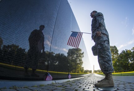 A U.S. Army Reserve soldier reads some of the 58,272 names etched into "The Wall" of the Vietnam Veterans Memorial in Washington D.C. as the sun rises July 22, 2015. (U.S. Army photo by Sgt. Ken Scar) 