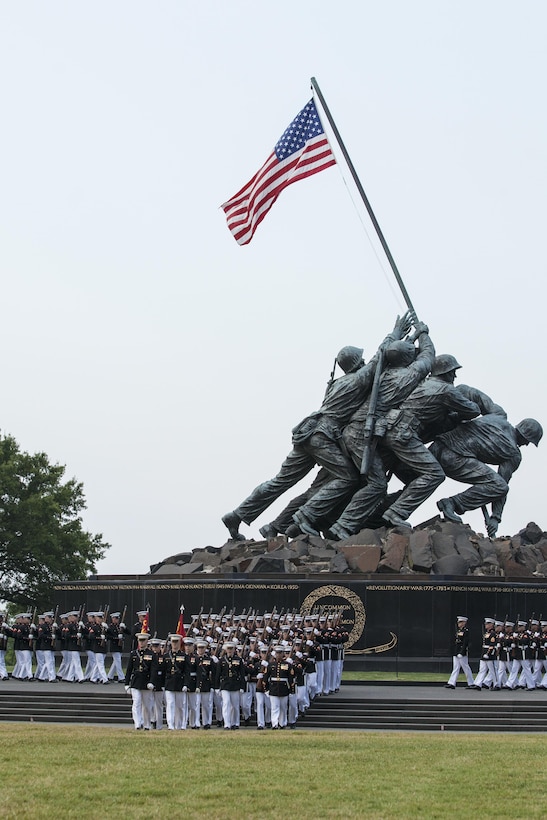 U.S. Marines with the Silent Drill Platoon march in front of the Marine Corps War Memorial during a sunset parade, Arlington, Va., July 28, 2015. U.S. Navy Adm. Harry B. Harris, U.S. Pacific Command, was the guest of honor for the parade, and Gen. John M. Paxton, assistant commandant of the Marine Corps was the hosting official. Since September 1956, marching and musical units from Marine Barracks Washington, D.C., have been paying tribute to those whose “uncommon valor was a common virtue” by presenting sunset parades in the shadow of the 32-foot high figures of the United States Marine Corps War Memorial. (U.S. Marine Corps photo by Lance Cpl. Samantha K. Draughon/Released)
