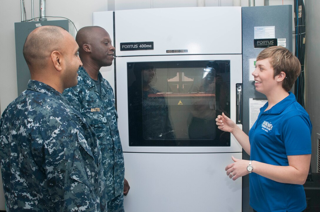 Carolyn Lambeth, a mechanical engineer at Combat Direction Systems Activity, right, explains the process on addictive manufacturing and 3D printing to Sailors during the U.S. Navy's first Maker Faire titled Print the Fleet. The event showcased additive manufacturing techniques for Sailors and other stakeholders attending the two-day event. (U.S. Navy photo by Mass Communication Specialist Seaman Jonathan B. Trejo/ Released)