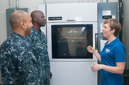 Carolyn Lambeth, a mechanical engineer at Combat Direction Systems Activity, right, explains the process on addictive manufacturing and 3D printing to Sailors during the U.S. Navy's first Maker Faire titled Print the Fleet. The event showcased additive manufacturing techniques for Sailors and other stakeholders attending the two-day event. (U.S. Navy photo by Mass Communication Specialist Seaman Jonathan B. Trejo/ Released)