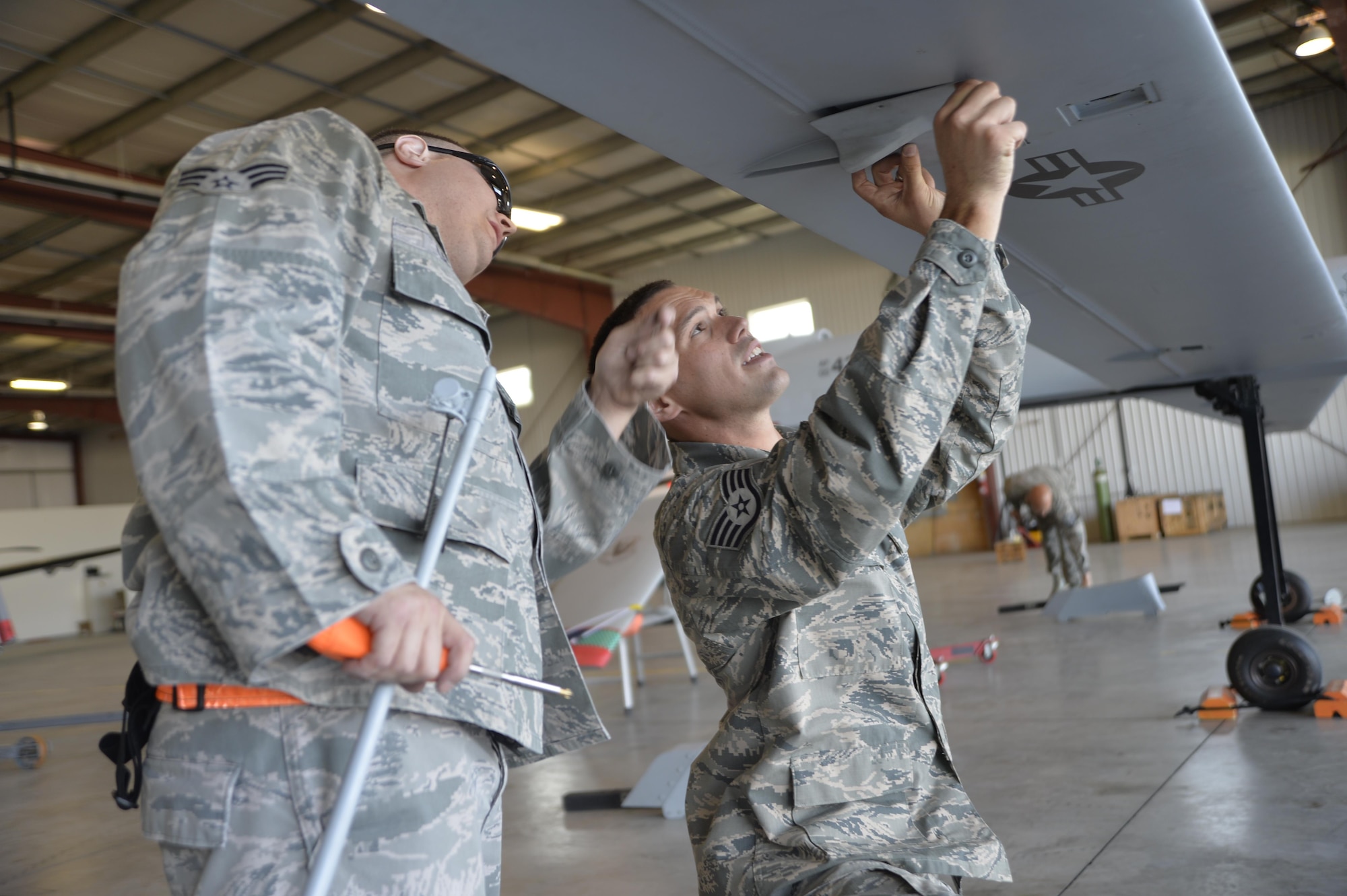 Senior Airman Derek Lee, a 432nd Aircraft Maintenance Squadron avionics technician, and Staff Sgt. Craig Stewart, a 432nd AMXS MQ-1 Predator crew chief, assemble an MQ-1 Predator static display July 24, 2015, in Lethbridge, Alberta province, Canada. The MQ-1 Predator is a multirole aircraft used primarily for intelligence, surveillance, and reconnaissance and can also be used for kinetic strikes. (U.S. Air Force photo/Airman 1st Class Christian Clausen)