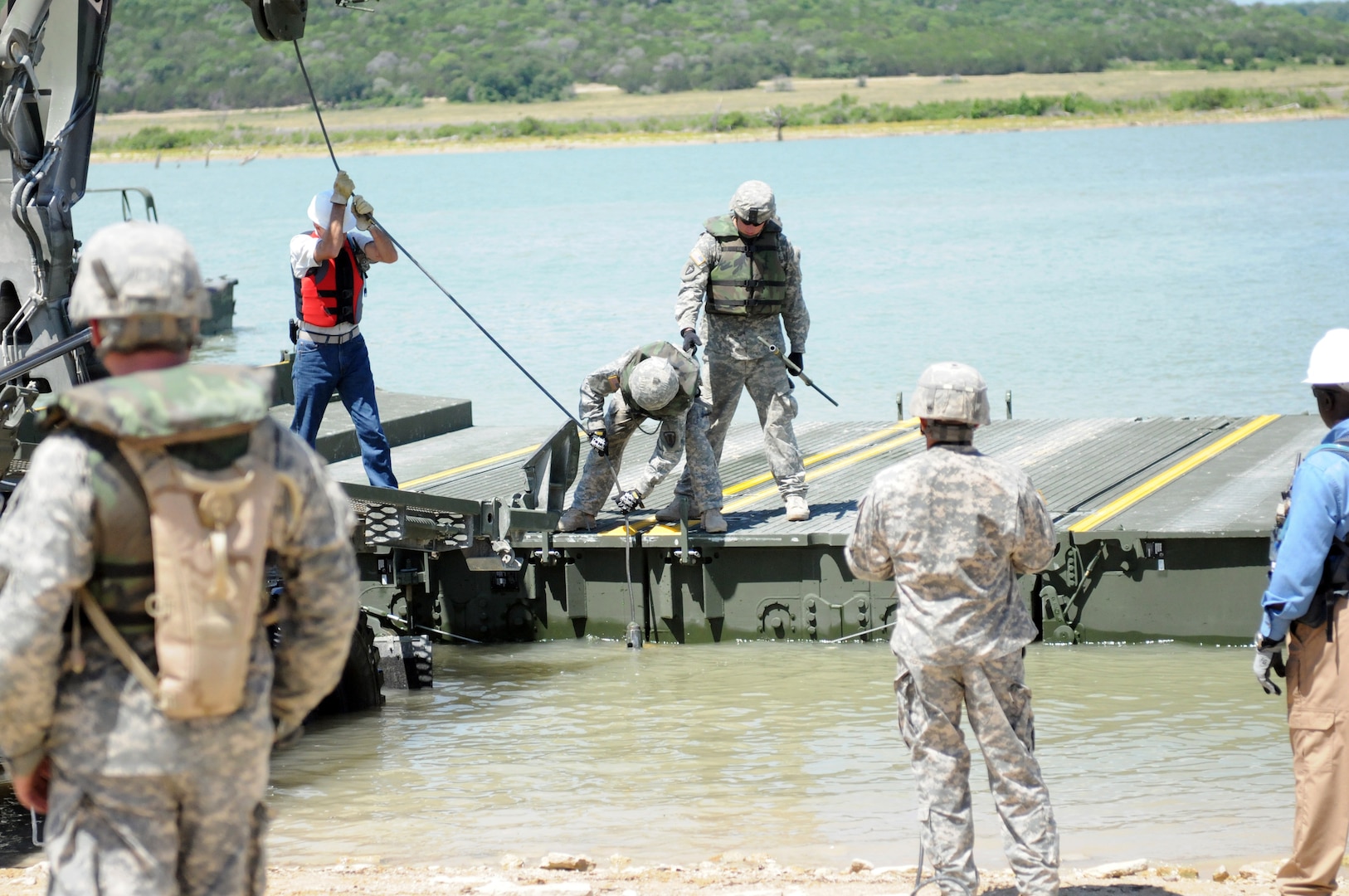 Texas Army National Guard Soldiers attach an improved ribbon bridge bay to the M1977 common boat transporter while conducting IRB operations during Operator New Equipment Training. The Soldiers are assigned to the 551st Multi-Role Bridge Company, 386th Engineer Battalion, 176th Engineer Brigade
