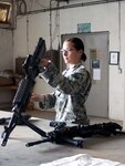 Army Spc. Crystal Gregan, a Mine Resistant Ambush Protected vehicle driver and gunner assigned to Golf Company, 3rd Battalion, 116th Cavalry Regiment, 77th Sustainment Brigade, 310th Expeditionary Sustainment Command, disassembles an M-240B machine gun after a convoy mission at Joint Base Balad, Iraq July 7, 2011.