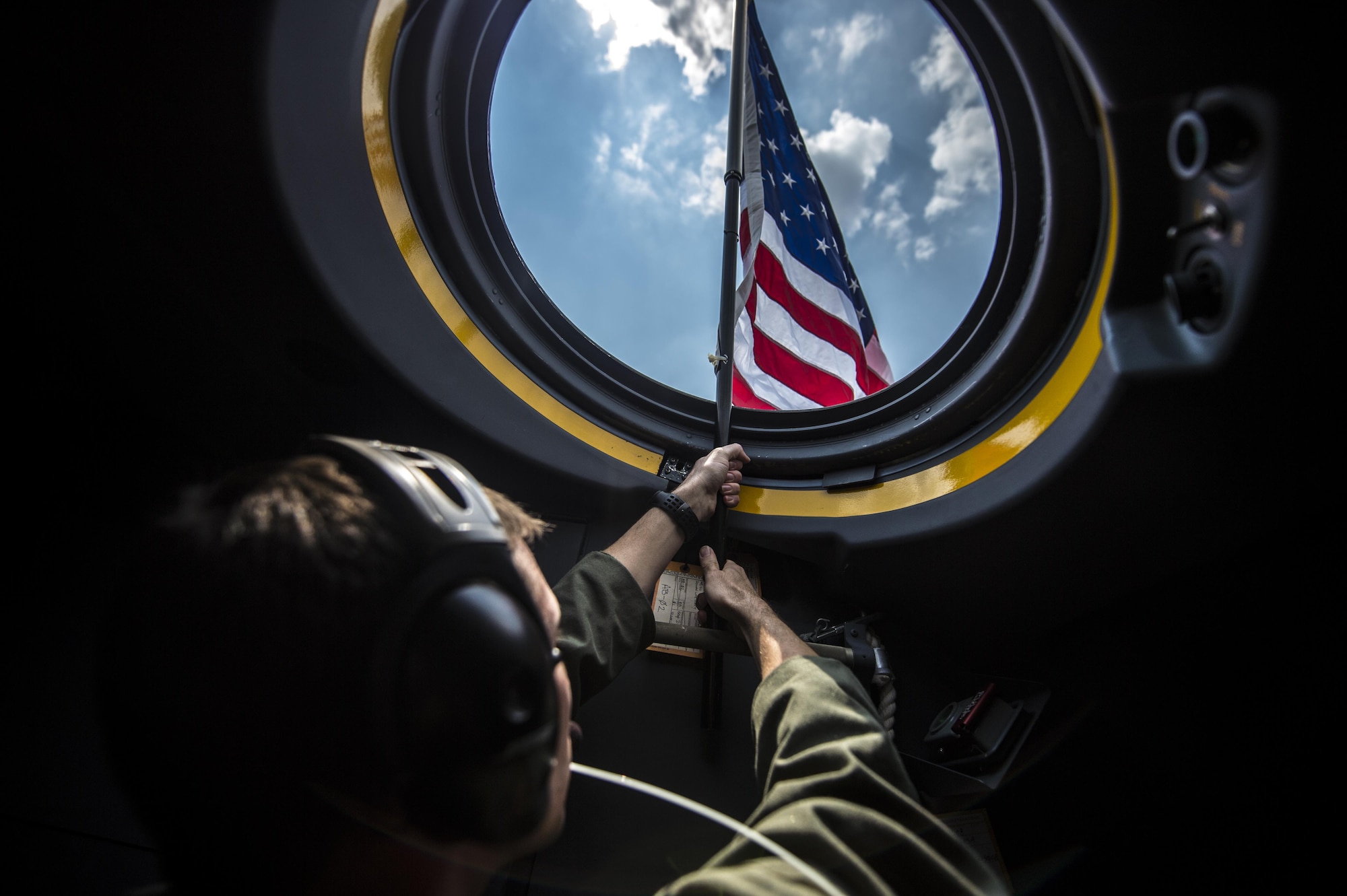 Capt. Brian Schmidt, 1st Special Operations Group Detachment 2 pilot, raises a flag out of the first AC-130J Ghostrider on Hurlburt Field, Fla., July 29, 2015. The 1st Special Operations Wing received Air Force Special Operations Command’s first AC-130J that will be flown by the 1st SOG Det. 2 and maintained by the 1st Special Operations Aircraft Maintenance Squadron. (U.S. Air Force photo/Senior Airman Christopher Callaway)