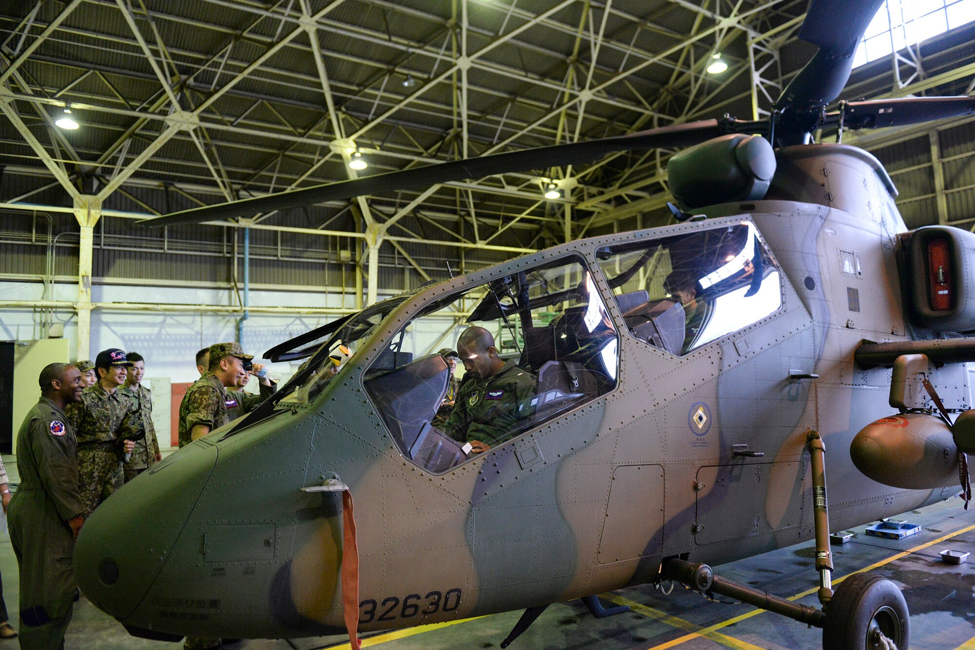 Aircrew members with the 459th Airlift Squadron take seats in an OH-1 Omega helicopter at Tachikawa Air Base, Japan, July 16, 2015. The OH-1, which was part of a static display hosted by Japan Ground Self-Defense Force, is the first helicopter designed and manufactured in Japan. (U.S. Air Force photo by Airman 1st Class Elizabeth Baker/Released)