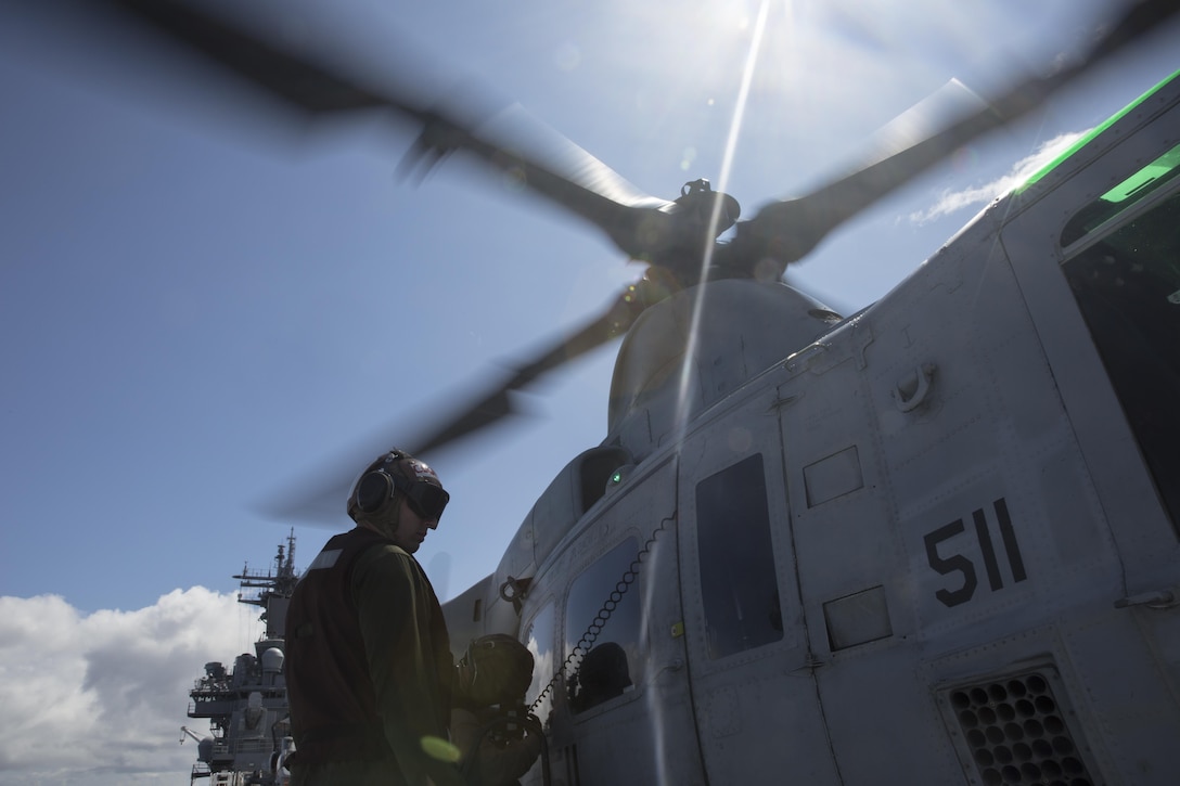Cpl. Michael Lewis, left, an aviation mechanic with Marine Light Attack Helicopter Training Squadron 303, and a Kannapolis, North Carolina native, and Sgt. Tyler Goodwin, an avionics technician with HMLAT-303, and a Cleveland native, perform maintenance on a UH-1Y Huey aboard the USS Boxer, at sea  July 26. Marines with HMLAT-303 prepared the aircraft for the 2015 Seattle Seafair. 
