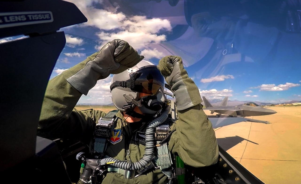 Air Force Capt. Craig “Rocket” Baker, F-16 Viper Demo Team pilot, signals to an F-22 Raptor before takeoff at the Heritage Flight Certification and Training Course at Davis-Monthan Air Force Base, Ariz., Feb. 27, 2015. During the four day course, Baker flew eight sorties practicing his demonstration. U.S. Air Force photo