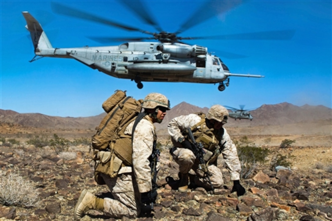 Navy Petty Officer 3rd Class Steven Martinez, left, and Marine Corps Staff Sgt. Joseph Quintanilla brace as a CH-53E Super Stallion with Marine Heavy Helicopter Squadron 366 takes off after inserting the company into a landing zone on Marine Corps Air Ground Combat Center Twentynine Palms, Calif., July 26, 2015. Martinez, a corpsman, and Quintanilla, a platoon sergeant, are assigned to the 3rd Marine Regiment. 